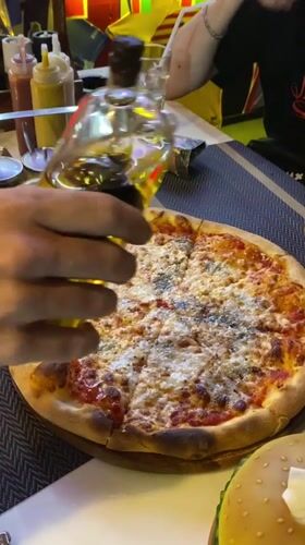 Pizza preparation captured in evening meal in Thailand