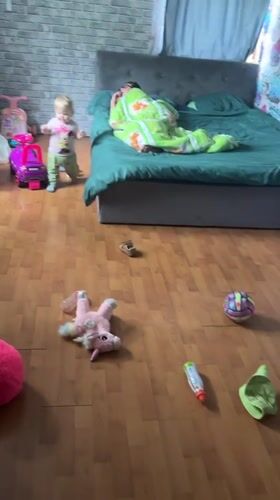 Child and person captured in domestic bedroom scene, Vesyoloye