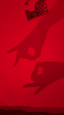 Shadow play on a red wall, cat hiding behind a jacket.
