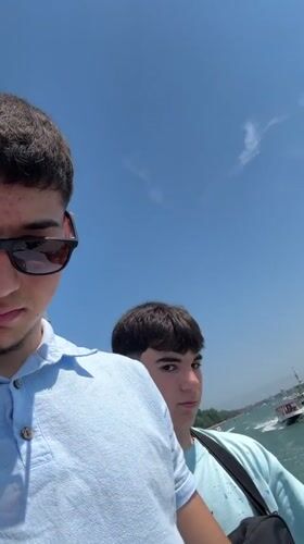 Young men enjoy sunny boat ride through Venice canals