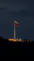 Russian flag flies illuminated at night in Krasnoyarsk