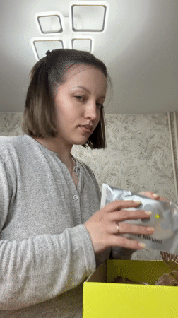 Woman unboxes Golden Apple beauty products in Russian home