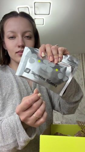 Woman unboxes Golden Apple beauty products in Russian home