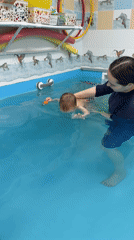 Swimming lesson for toddler at indoor pool in Rusanovo
