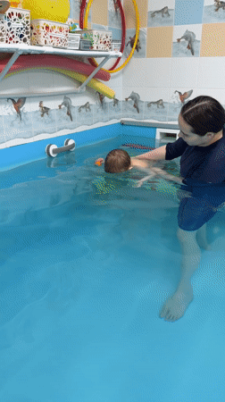Swimming lesson for toddler at indoor pool in Rusanovo