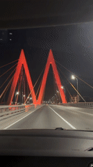 Night traffic crosses illuminated suspension bridge in Kazan