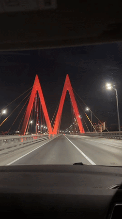 Night traffic crosses illuminated suspension bridge in Kazan