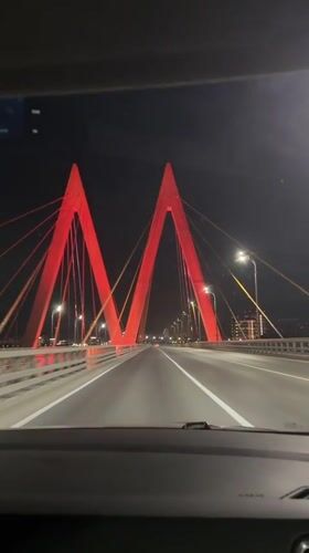 Night traffic crosses illuminated suspension bridge in Kazan