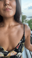 Woman with wet hair smiles from balcony in Peleana