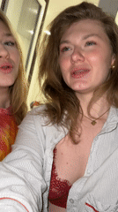 Two women record selfie video indoors