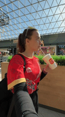 Woman drinks at Perm shopping mall with geometric ceiling