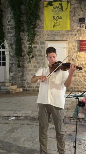 Live violin on a cobblestone street in Budva's old town