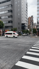 Ambulance crosses street in Chuo, Japan early morning
