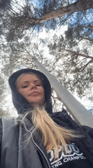 Woman documents lakeside forest visit with dog in morning outing