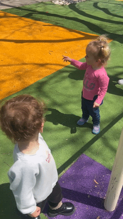 Children play at Kiryat Bialik playground with cat