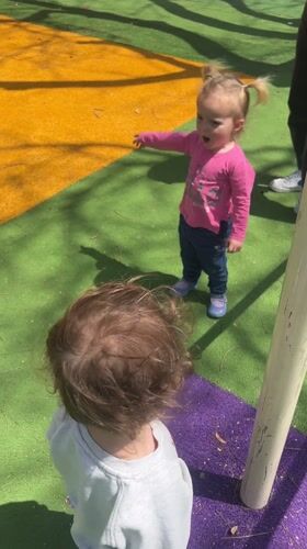 Children play at Kiryat Bialik playground with cat