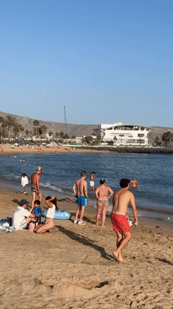 Busy afternoon on Arona's palm-lined beach promenade