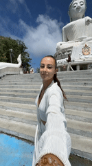 Woman visits Buddha statue at Thai temple in Chalong
