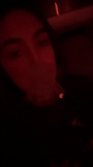 Woman smoking marijuana in red-lit Mexico City room