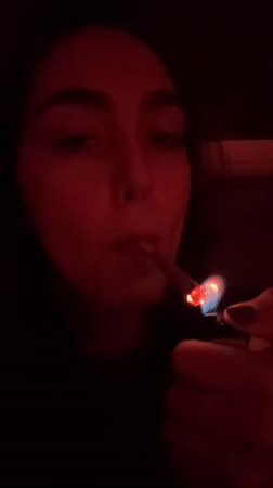 Woman smoking marijuana in red-lit Mexico City room