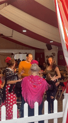 Group dancing in striped tent captured in Sant Adrià