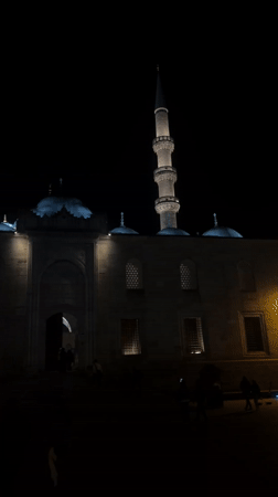 Istanbul mosque glows peacefully at night as people stroll