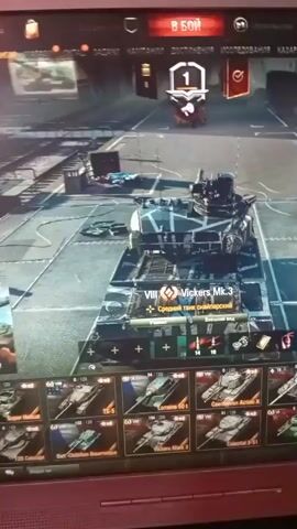 The video shows a computer screen displaying the user interface for a video game, likely a tank simulation game. In the center of the screen is a 3D model of a tank labeled "VIII Vickers Mk.3," a medium tank. The tank has a camouflage pattern. Below the tank, a row of other tank icons is visible, indicating a garage or selection screen. The top of the screen shows game-related menus and indicators, including "В БОЙ" (To Battle) and various icons. The overall environment appears to be a virtual garage or hangar. The video is shot from a slight angle, likely with a handheld device.