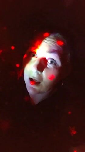 Colorful lighting illuminates people in Markovskii evening gathering