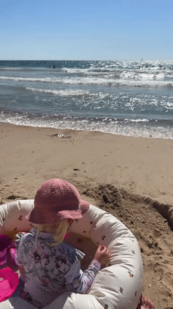 Toddler plays at Tel Aviv beach while Lexus sits in seaside lot