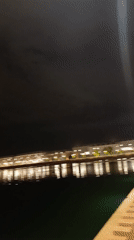 Two men photograph themselves at night near Meknes waterfront