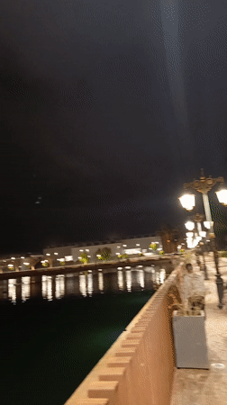 Two men photograph themselves at night near Meknes waterfront