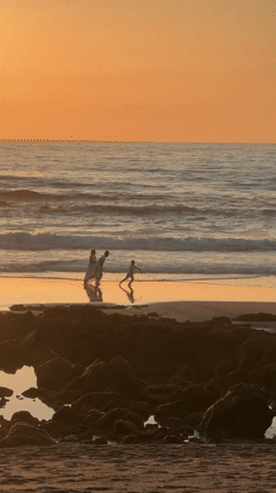 Families enjoy sunset stroll on Bidart beach, France