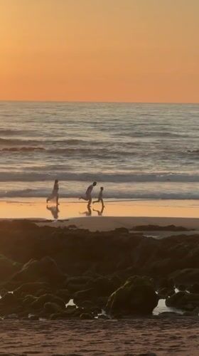 Families enjoy sunset stroll on Bidart beach, France