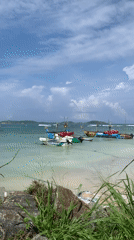 Morning beach scene with fishing boats and surfers in Mirissa