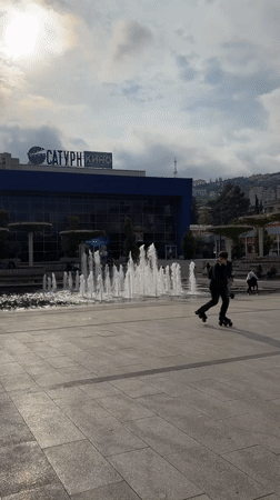 Brass band performs in Yalta square, draws dancer and skater