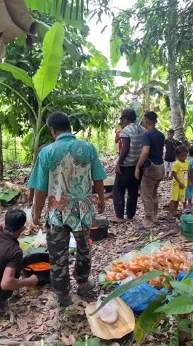Communal gathering with open-fire cooking in tropical Indonesia