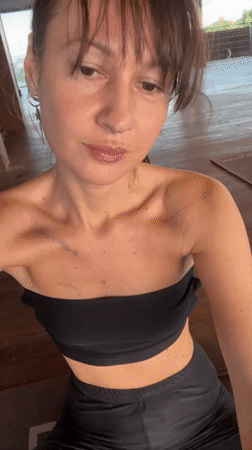 Woman practices yoga, documents session in Mengwi studio