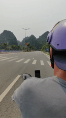 Motorcyclist travels marked road in Quang Hanh, Vietnam