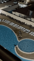 Night swimming captured at illuminated resort pool in Anapa
