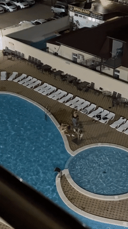 Night swimming captured at illuminated resort pool in Anapa