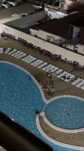 Night swimming captured at illuminated resort pool in Anapa