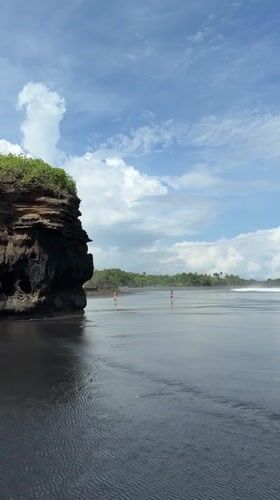 Visitors enjoy black sand beach in Selemadeg, Indonesia