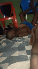 Child rests on bed in indoor domestic scene