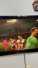 Resident records soccer match featuring Manuel Neuer on TV