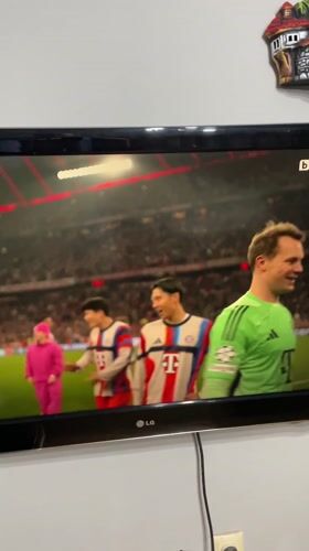 Resident records soccer match featuring Manuel Neuer on TV