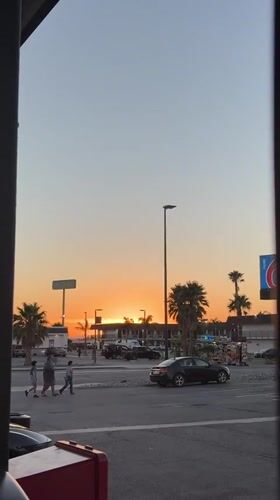 Golden sunset framed by dark vertical structures in Lost Hills
