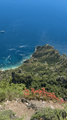 Tourist captures scenic Anacapri coastal views with Faraglioni formations