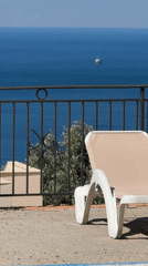 Morning terrace view captures pool, ocean, distant ship in Montenegro
