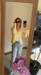 Woman takes mirror selfies in yellow cardigan, Riga
