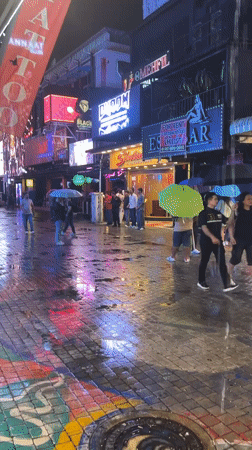 Rainy night street activity continues in Pattaya commercial district